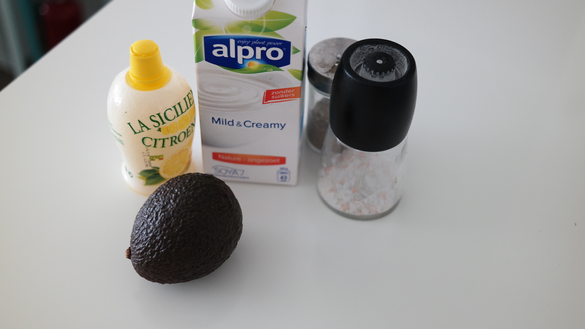 Ingrediënten voor romige avocadosaus: sojayoghurt, avocado, zout, peper en citroensap